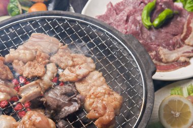 Japon restoranındaki ızgarada et ve sebze pişiren kişinin yakın çekim görüntüsü 