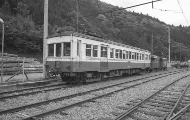 Tren raylarında giden bir trenin siyah beyaz fotoğrafı..