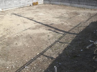 Etrafı beton bloklarla çevrili boş bir arazi.