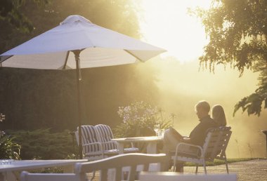 Gün batımında şemsiye altında dinlenen çift