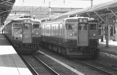 Güneş ışığı Japon şehrinden geçen trenleri taşıyan rayların paralel hatlarını yakalıyor..