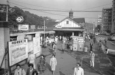 Japonya 'nın binaları, yolları, arabaları ve yürüyen insanlarla dolu siyah ve beyaz sokak fotoğrafı. 