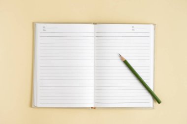 Masanın üzerinde kalem olan not defterini aç