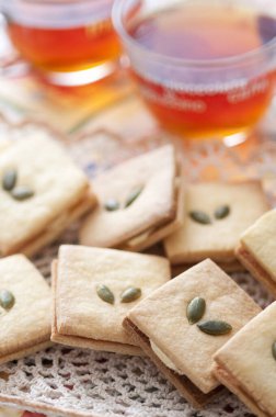 Bir tabak kraker, kabak çekirdeği ve bir fincan çay.