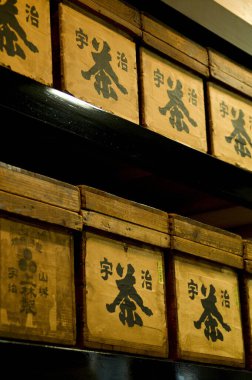 İçinde Japon yazı karakterlerinin olduğu istiflenmiş ahşap kutular.