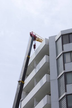 Modern apartman balkonlarının yanında vinç kaldırma malzemeleri