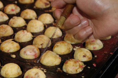 Sıcak tavada takoyaki topları pişiriyorum.