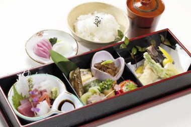 Birçok küçük tabakta çeşitli Japon yemeklerini gösteren mutfak fotoğrafı.