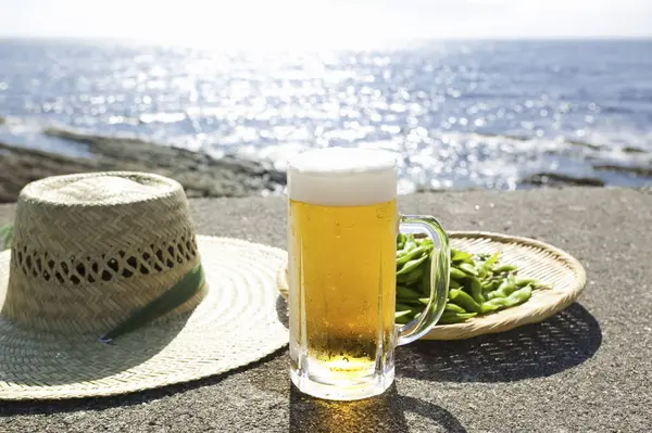 Cerveja Com Ervilhas Verdes Chapéu Palha Fundo Praia — Fotografia de Stock