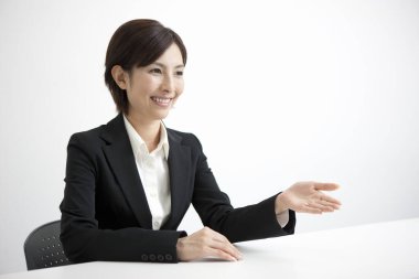 Ofiste masa başında oturan Asyalı iş kadını 