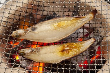 Arkadaki ızgarada ızgara balık var, kapat.