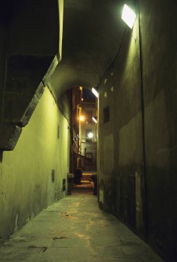 Eski şehirde geceleri yanan lambalar olan dar bir sokak.