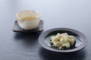 Bir fincan çay ve lezzetli Japon tatlıları masada.