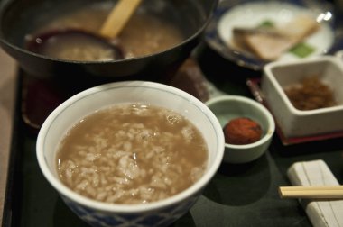 Karışık mezelerin yanında bir kase pirinç lapası.