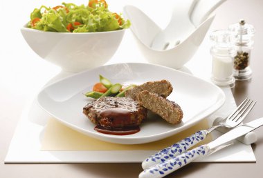 Tavuk eti, sebze ve soslu bir tabak salata.