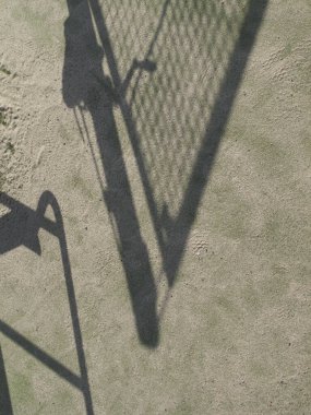 Güneşli bir günde tenis kortu ve gölgesi      