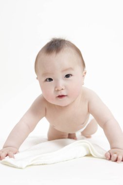 Beyaz arka planda bebek bezi takmış sevimli Asyalı bebeğin stüdyo portresi