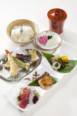 Birçok küçük tabakta çeşitli Japon yemeklerini gösteren mutfak fotoğrafı.