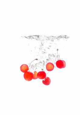 Beyaz arka planda meyve suyu damlatan kiraz meyveleri.