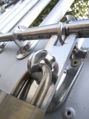 Kapalı, parlak metal kapı. Dışarıdaki asma kilit ile kilitlenmiş.