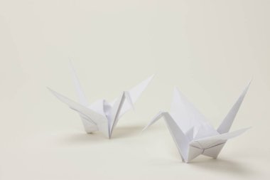 Beyaz arkaplanda kağıttan yapılmış origami kuşu