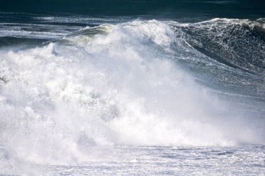 Denizdeki dalgaların gündüz görüntüsü. Denizin üzerindeki mavi gökyüzü
