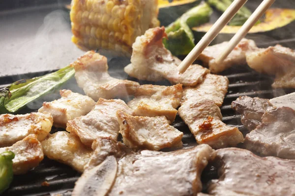 用筷子和美味的烧烤把肉和蔬菜放在烤架上 — 图库照片