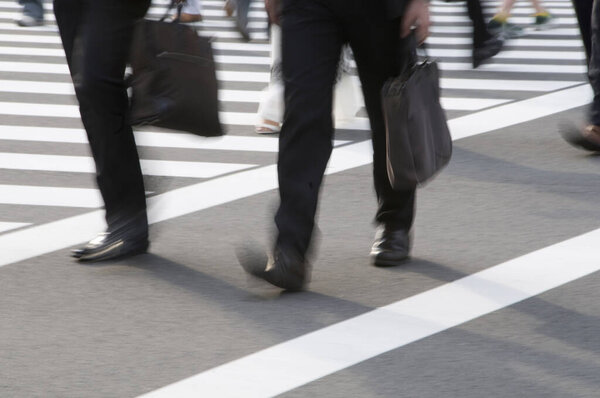 blurred motion view of legs of people walking in city                 