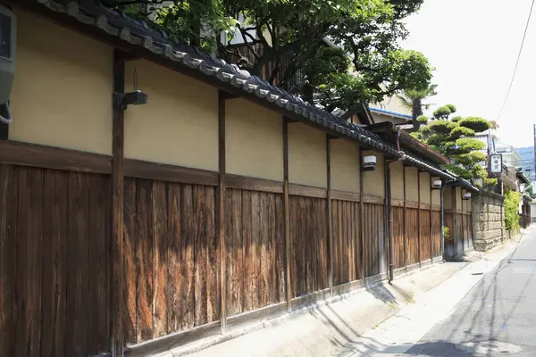 Geleneksel ahşap çitler dar ve sessiz bir sokak ışığı altında parlıyor.