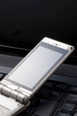 Bir bilgisayar klavyesinin üzerine yerleştirilmiş akıllı telefon, kullanıma hazır.