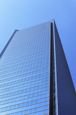 Mavi gökyüzüne karşı modern ofis binasının düşük açılı görüntüsü    