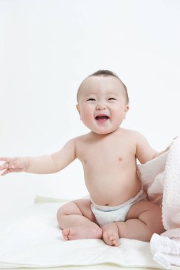 Beyaz arka planda bebek bezi takmış sevimli Asyalı bebeğin stüdyo portresi