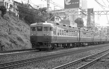 Yolcu treni, parlak gökyüzünün altında Japon demiryolu sahnesinin ön planına hakim..