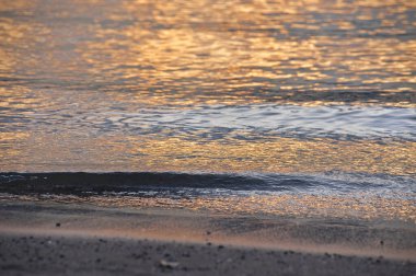 Gün batımında sahildeki deniz dalgalarının güzel manzarası.         