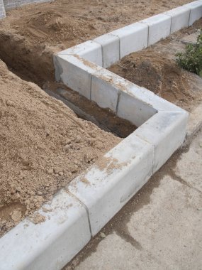 İnşaat alanındaki kumlu toprağın sınırındaki beton kaldırımlar