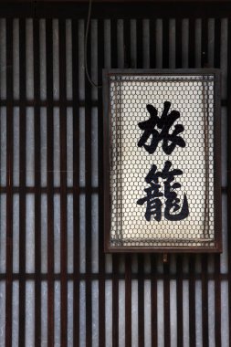 Geleneksel Japon feneri ahşap duvarlı arka planda asılı.