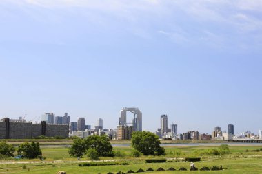 Japonya 'nın Osaka kentindeki yeşil bir parktan şehir merkezindeki yüksek katlı apartmanlar. 