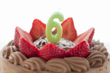 Çikolatalı pasta ve çilekli altı numaralı mum.