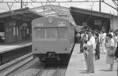 Yolcu treninin yer aldığı bir kamu istasyonunun siyah beyaz fotoğrafı.