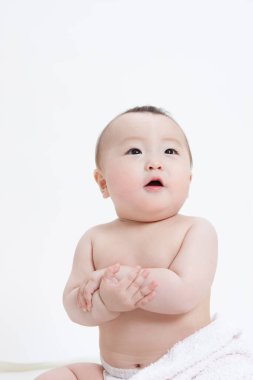 Beyaz arka planda bebek bezi takmış sevimli Asyalı bebeğin stüdyo portresi