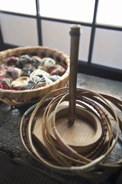 Etrafı renkli iplik yumaklarıyla çevrili ahşap bir çember.