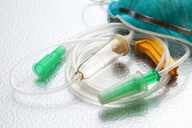 Yakın plan, koruyucu cerrahi maskenin yanında tıbbi infüzyon olduğunu gösteriyor.