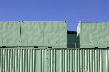 Mavi gökyüzü arkaplanlı yeşil metal kaplar