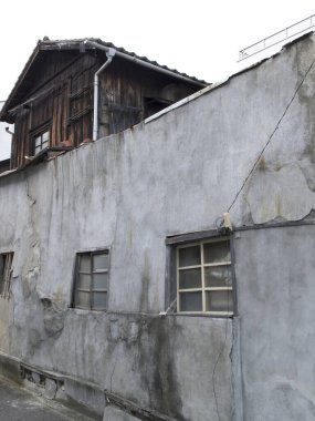 Yıpranmış doku ve pencereleri gösteren eski bina duvarı