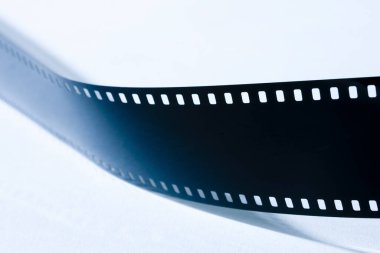 Beyaz arkaplanda film şeritlerinin yakın plan görüntüsü.         