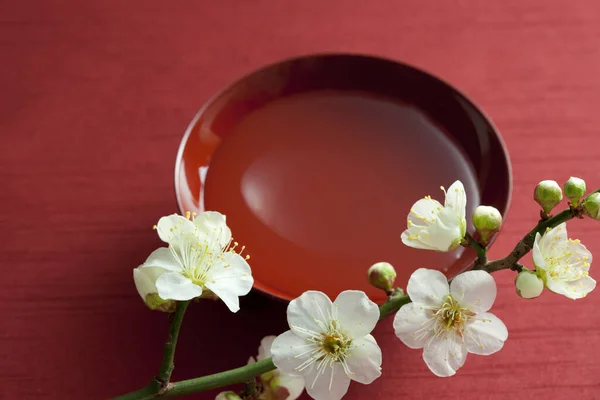 Pflaumenzweig Mit Blühenden Blumen Und Traditioneller Japanischer Tasse Mit Sake — Stockfoto