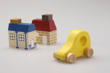 sarı ahşap oyuncak araba ve stüdyo arka planında iki ev 
