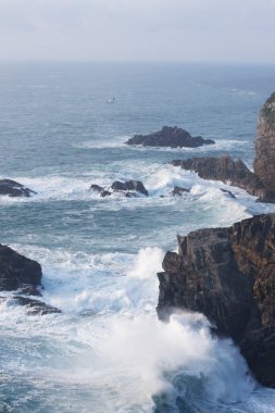 Dalgalar okyanusun kayalıklarında denize çarpıyor.