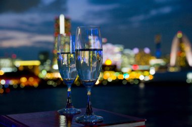 Gece şehrinde iki kadeh şarabın yakın plan görüntüsü      
