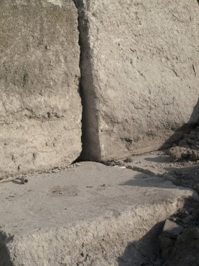 Yıpranmış taş bloklar sert, dikey bir köşe oluşturuyor.